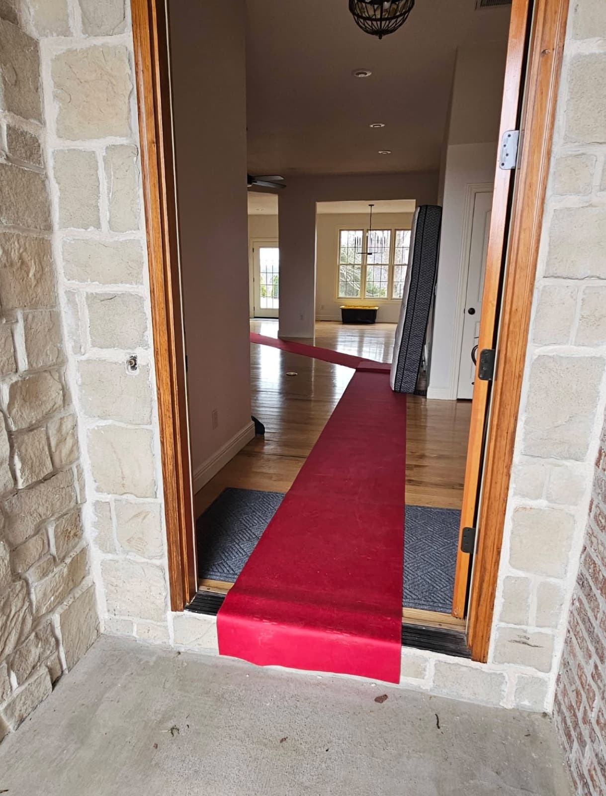 Red carpet floor runner laid down through a home entryway to protect hardwood floors during a move
